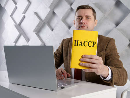 Manager shows Hazard Analysis and Critical Control Points HACCP documents.の写真素材