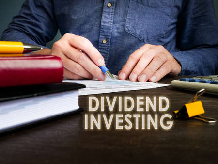 Dividend investing phrase and manager works with papers.の写真素材