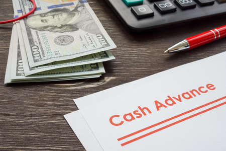 Papers for cash advance with calculator and money.の写真素材