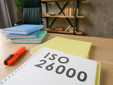 Desk with guide about iso 26000 on it.の写真素材