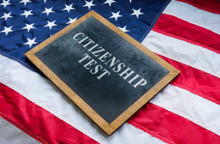 Citizenship test on the blackboard and USA flag.の写真素材