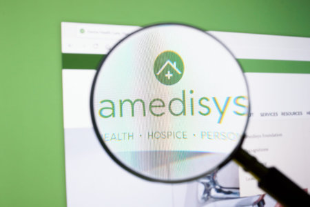 KYIV, UKRAINE - June 30, 2021. Magnifying glass and amedisys logo.