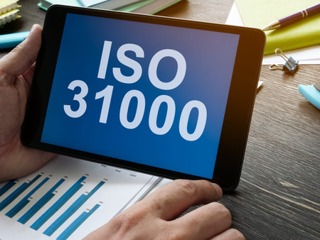 Hand holds tablet with data about ISO 31000.