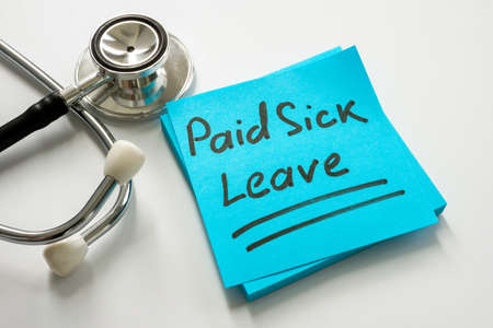 Paid sick leave handwritten on the sticker.の写真素材