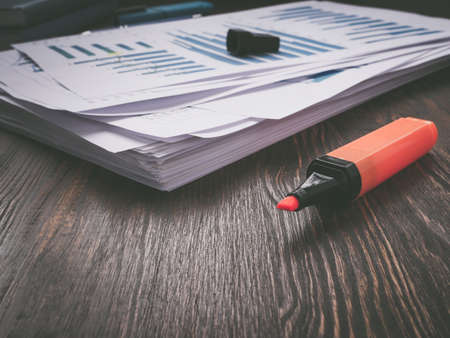 Stack of papers with financial report and taxes for audit and marker.の写真素材