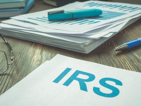 Abbreviation IRS and stack of financial papers.の写真素材