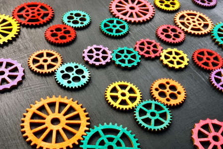 Multi-colored gear wheels on a dark surface. Variety and interaction.の写真素材