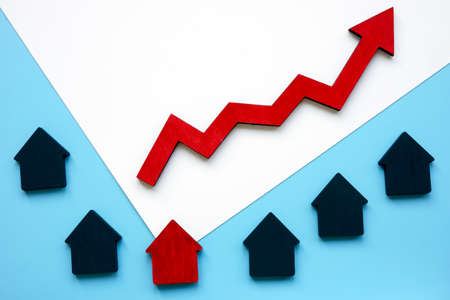 Small houses and an arrow symbolizing the rise in property prices. Real estate value.の写真素材