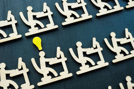Talent management. Employees at the computer and one with a good idea.の写真素材