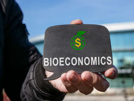 A man holds a tablet with word bioeconomy.の写真素材