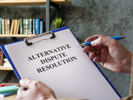 Man reads about alternative dispute resolution ADR.の写真素材