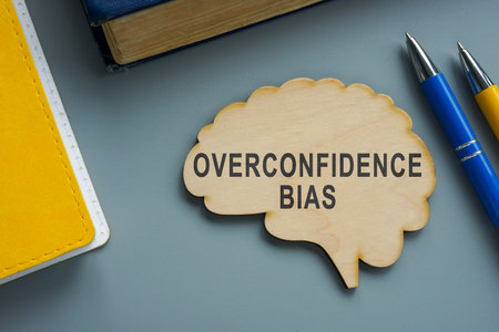 Wooden brain with words overconfidence bias on the desk.