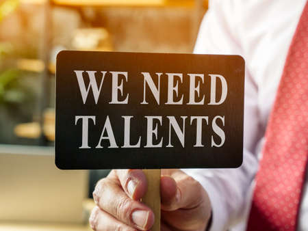 Man shows plate with sign We need talents. Recruitment concept.の写真素材