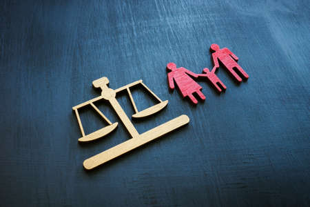 Family law concept. Figures of scales and families for adoption.の写真素材