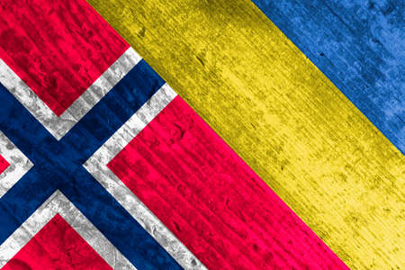 Flags of Ukraine and Norway on a wooden surface.の写真素材