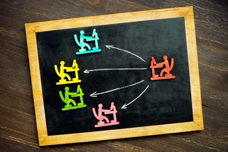 Blackboard with arrows and figurines. Delegating concept.の写真素材