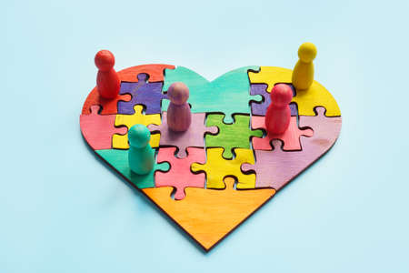 Togetherness and inclusion. Puzzle heart and colored figurines.の写真素材