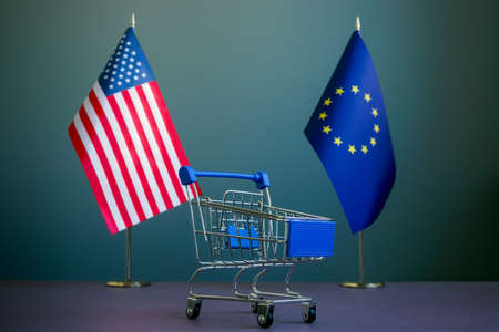 USA and EU flags and a shopping cart as a symbol of trade relations.の写真素材