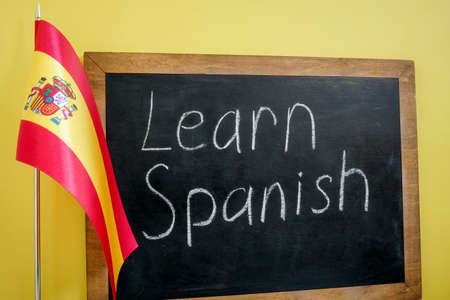 Learn Spanish sign on the blackboard and flag.の写真素材