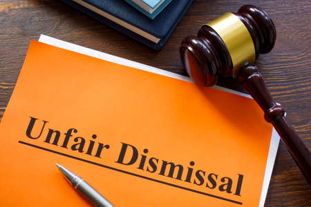 Report about unfair dismissal with book on the table.の写真素材