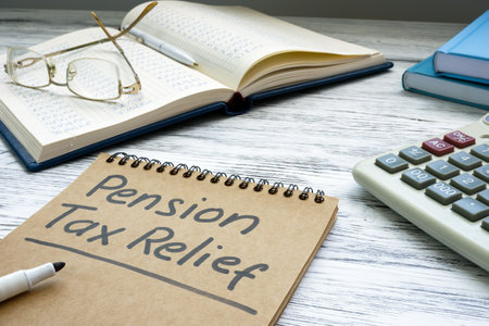 Pension tax relief sign and notepads on the desk.の写真素材