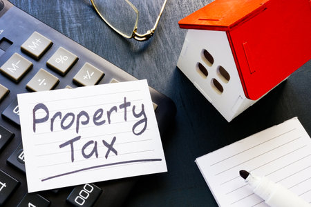 Property tax reminder on calculator and house model.の写真素材