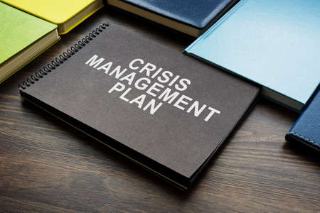 Crisis management plan and notepads on the desk.の写真素材