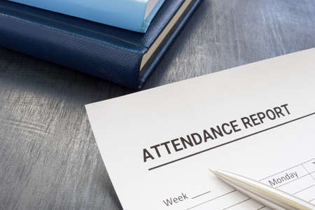 Attendance report form and pen near notepad.の写真素材