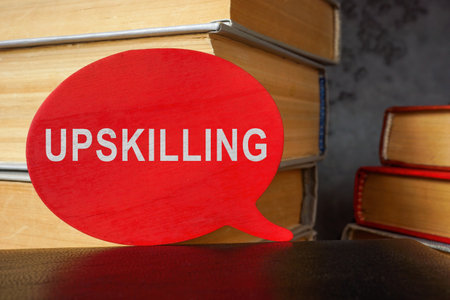 Stack of books and plate with word upskilling.の写真素材