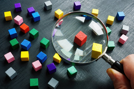 The hand is holding a magnifying glass. Talent acquisition concept.
