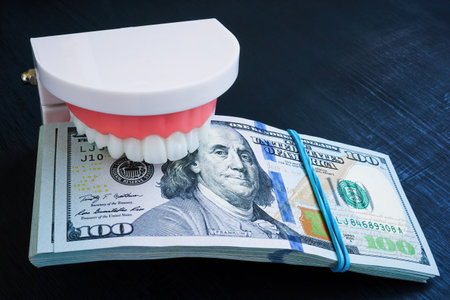 Jaws holding a stack of banknotes. Dental insurance concept.の写真素材