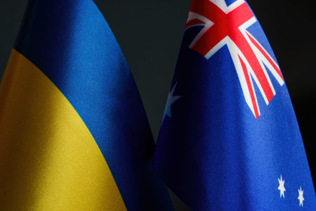 Nearby are the flags of Ukraine and Australia as a symbol of cooperation.