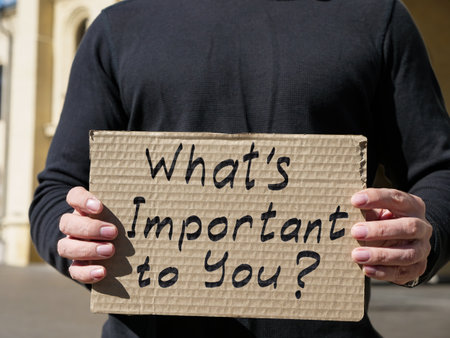Man holding a poster with the inscription What is important to you.の写真素材