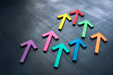 Multi-colored arrows on a dark surface as a symbol of teamwork and unity.