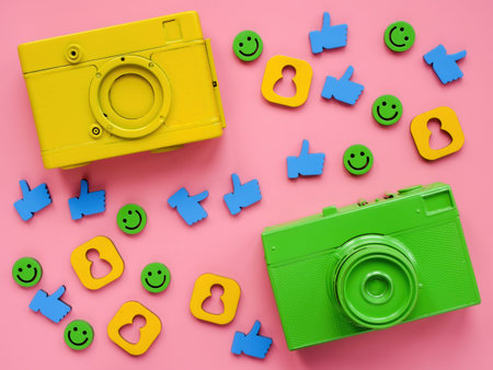 Two cameras, likes and smileys as content for social media.