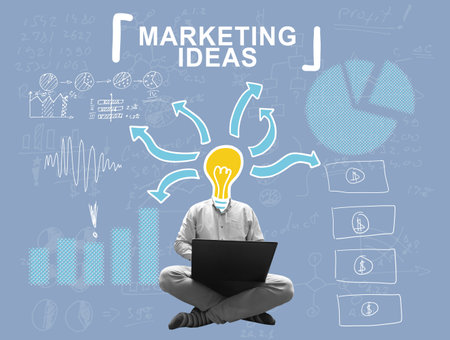 A man with a light bulb instead of a head works on a laptop. Marketing ideas concept.の写真素材