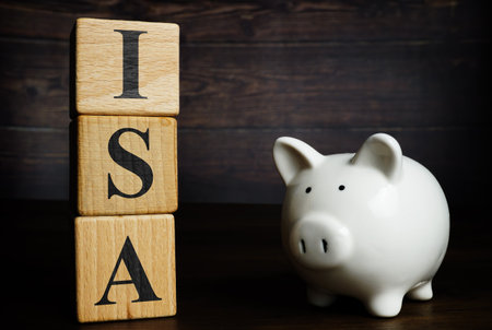 Wooden cubes with letters and piggy bank ISA Individual Savings Account.の写真素材