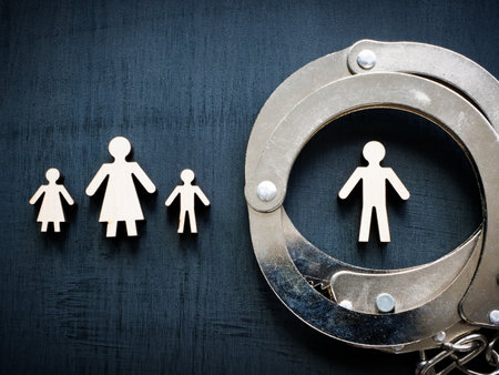 Family figurines and handcuffs as concept of domestic violence.の写真素材