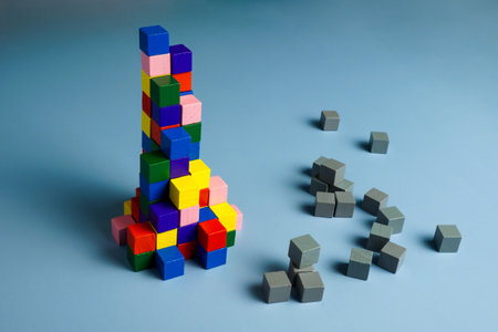 Teamwork, unity and diversity. Gray cubes and a pyramid of multi-colored ones.の写真素材