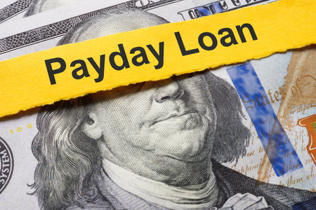 Payday loan concept. A strip of paper lies on the dollars.の写真素材