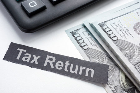 Tax return concept. Calculator, cash and strip of paper.の写真素材