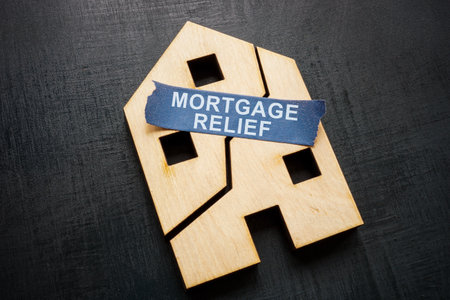 Mortgage relief. Broken house model and fastening tape.の写真素材