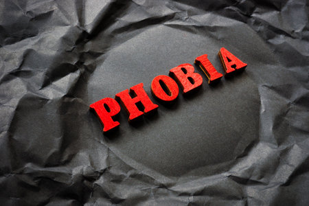 Black crumpled paper with the word phobia.の写真素材