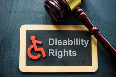 Tablet disability rights and gavel on a dark surface.の写真素材