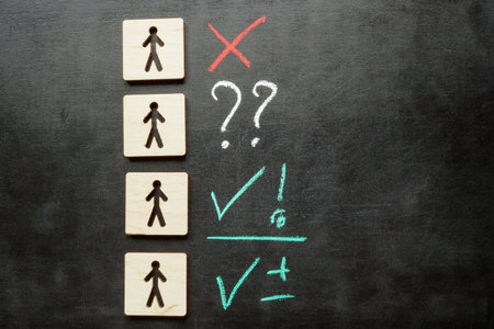 Figures representing employees or candidates with chalk marks for evaluation.の写真素材