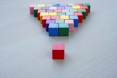 Inclusive Leadership abstract. A pyramid of colored cubes and the red one as the leader.