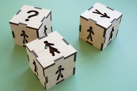 Cubes with figures of a woman, a man and question mark. Gender equality in employment and career.