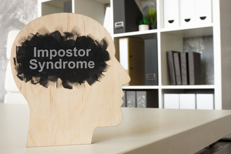 Office and model of head with phrase impostor syndrome.の写真素材