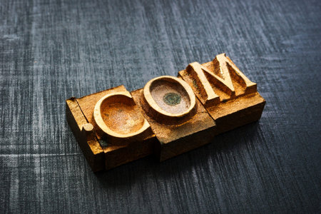 Close-up of typographic brass letters spelling com. Domain and online branding.