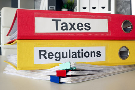 Folders with labels taxes and regulations. Financial compliance and legal obligations.の写真素材